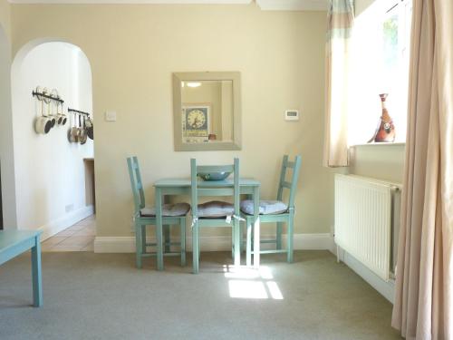 a dining room with a table and chairs and a mirror at Secret Garden Hideaway For Adults in Eastbourne