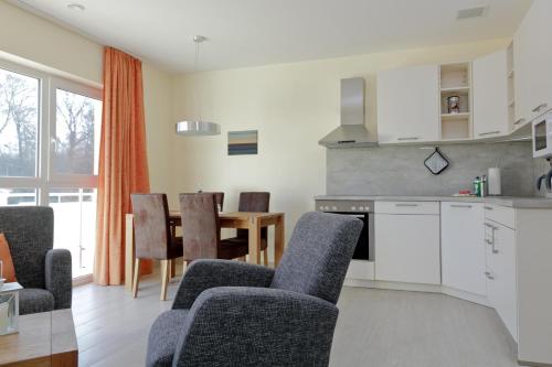 a kitchen and dining room with chairs and a table at Vineta Ferienpark Usedom in Ostseebad Koserow