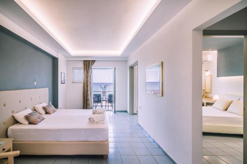 a hotel room with two beds and a balcony at Laplaya Beach in Malia