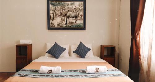 a bedroom with a bed with a picture on the wall at Borobudur Bed & Breakfast in Borobudur