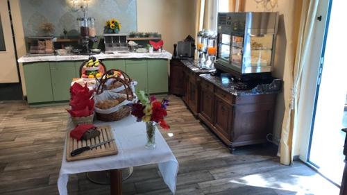 a kitchen with a table with flowers and a counter at Corso, Zimmer & Cafe, Hotel Garni in Pressbaum