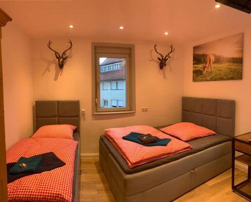 2 Betten in einem Zimmer mit Geweihen an der Wand in der Unterkunft Hotel Waldhorn in Stuttgart