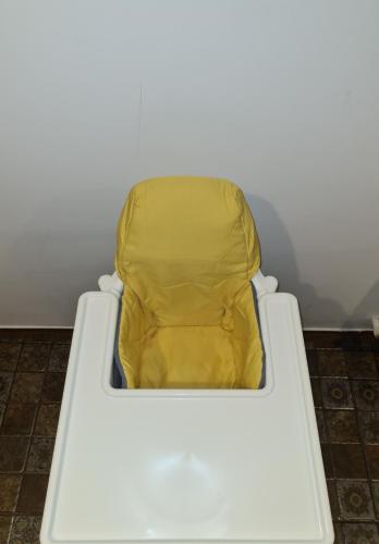 a white baby crib with a yellow seat at Alex Residence in Otopeni