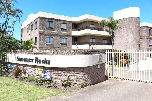 un bâtiment avec un panneau qui lit les rochers d'été dans l'établissement Summer Rocks 28, à Margate