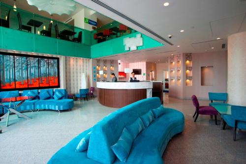 a lobby with a blue couch and a bar at Holiday Inn Express & Suites Queretaro by IHG in Querétaro
