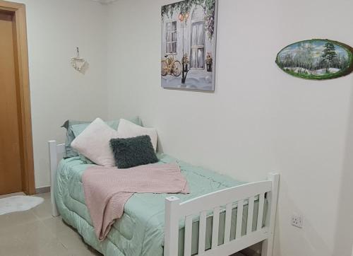 sypialnia z łóżeczkiem dziecięcym z poduszkami w obiekcie Green Sky Hostel w Dubaju
