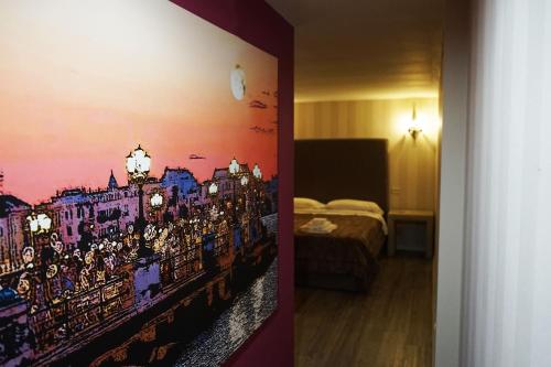 een slaapkamer met een schilderij van een stad aan de muur bij Dante's Room by Apulia Accommodation in Bari