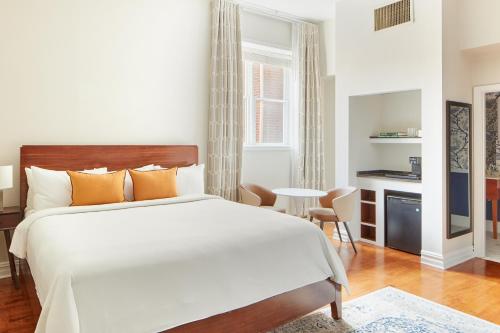 een slaapkamer met een groot wit bed en een tafel bij The Arco powered by Sonder in Philadelphia
