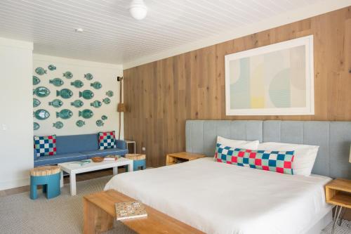 um quarto com uma cama branca e um sofá azul em Coral Sands Hotel em Harbour Island