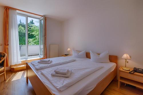 1 cama blanca grande en una habitación con ventana en Hotel Haus Oberland en Masserberg