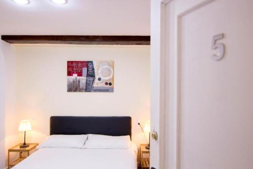 - une chambre avec un lit blanc et une photo sur le mur dans l'établissement B&B - El Magnanimo, à Valence