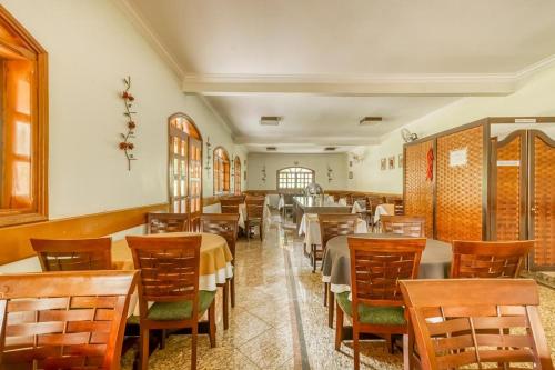a dining room with wooden tables and chairs at Jardin Park Hotel in Jardinópolis