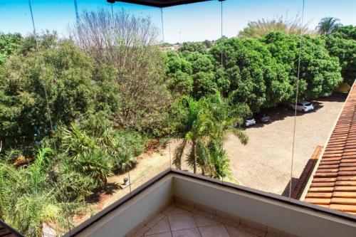a balcony with a view of a parking lot and trees at Jardin Park Hotel in Jardinópolis