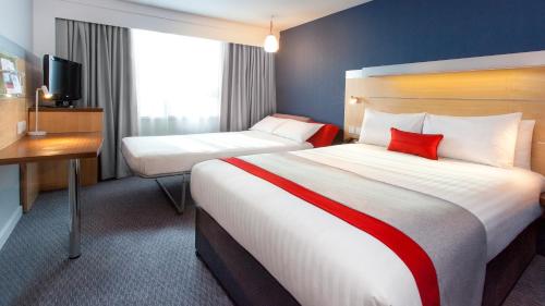 a hotel room with two beds and two lamps at Holiday Inn Express London Limehouse, an IHG Hotel in London