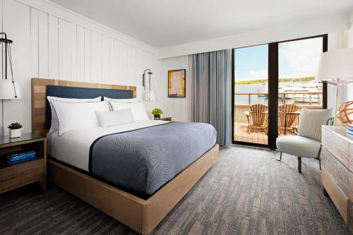 a hotel room with a bed, chair, and a window at Gurney's Star Island Resort & Marina in Montauk