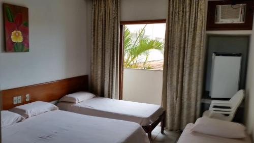 um quarto de hotel com duas camas e uma janela em Quiriri Park Hotel em Prado