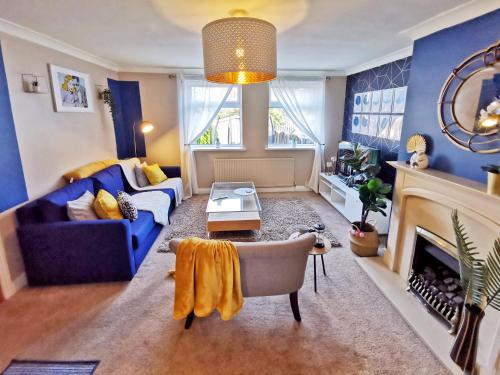 a living room with blue walls and a blue couch at Highstone 4 Bedrooms Home 7 Beds With Parking and Garden in Barnsley