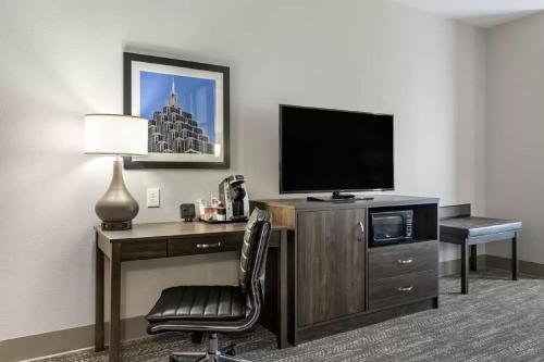 a hotel room with a desk with a television and a chair at Comfort Suites McDonough Atlanta South in McDonough