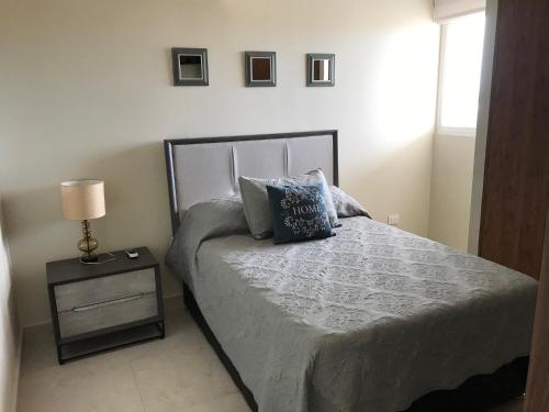 a bedroom with a bed with a night stand and a lamp at Departamento con espectacular vista a la montaña. in Puerto Vallarta
