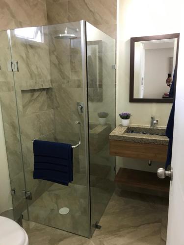 a bathroom with a glass shower and a sink at Departamento con espectacular vista a la montaña. in Puerto Vallarta