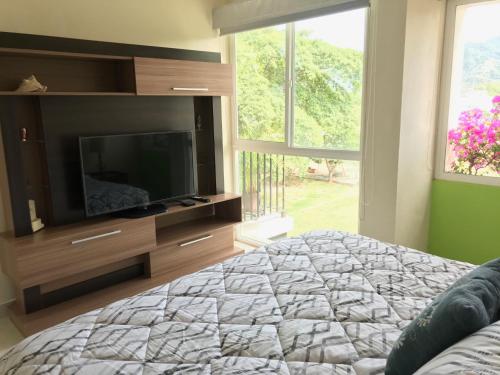 a bedroom with a flat screen tv and a bed at Departamento con espectacular vista a la montaña. in Puerto Vallarta