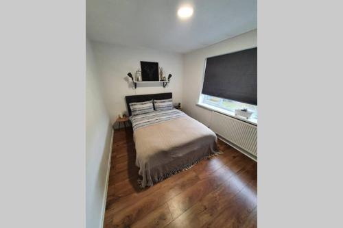 a bedroom with a bed and a large window at Entire Apartment! 2 double beds, sleeps upto 4 in Oldbury