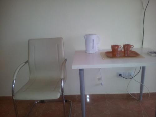 a white table with a chair next to a table at Sandanski Peak Guest Rooms in Sandanski