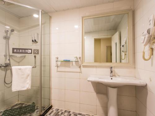蘇州的住宿－7天酒店·苏州狮山龙湖天街店，浴室配有盥洗盆和带镜子的淋浴