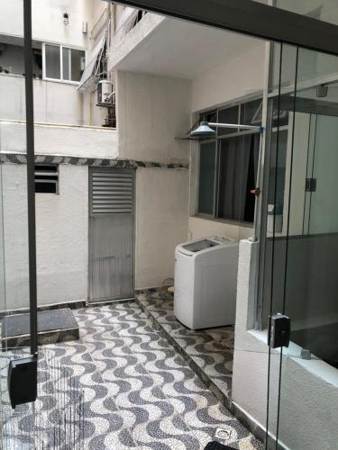 Guest House Copacabana Hostel في ريو دي جانيرو: حمام مع غسالة ملابس في مبنى