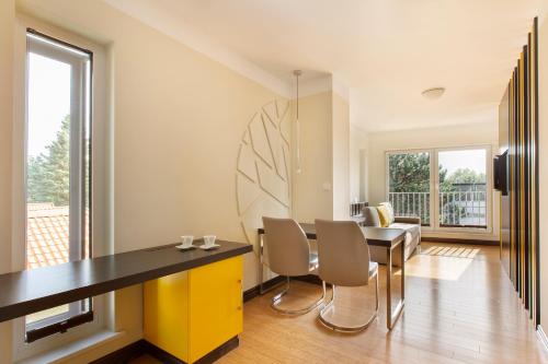 a dining room with a yellow and black table and chairs at Villa Buki Pokoje & SPA in Jastrzębia Góra
