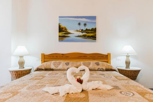two swans are sitting on a bed at Residence Fior di Sulcis in Calasetta
