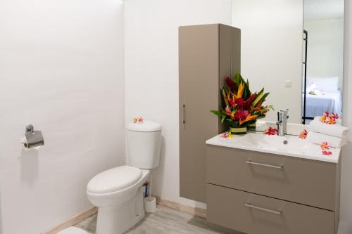 y baño con aseo, lavabo y espejo. en Matira Sandy Home 658 DTO-MT en Bora Bora