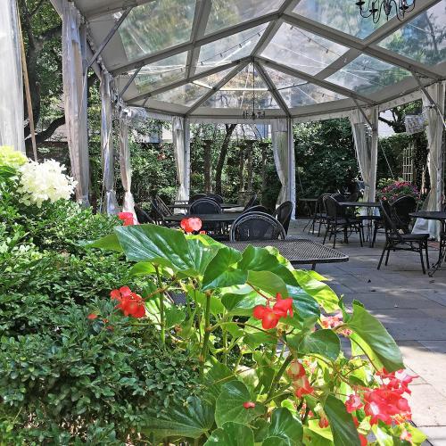 a conservatory with flowers and tables and chairs at Morris House Hotel in Philadelphia