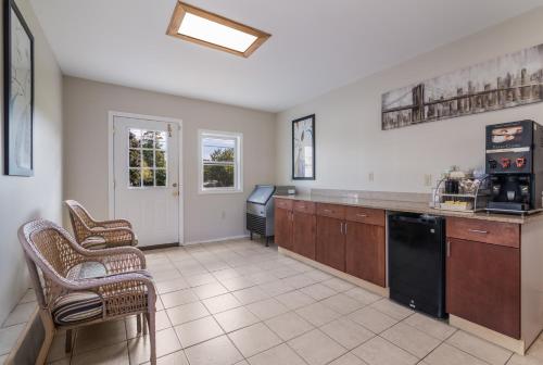 a large kitchen with a counter and chairs in it at Americas Best Value Inn Scarborough Portland in Scarborough