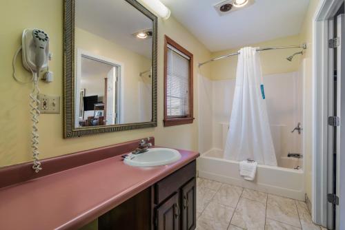 a bathroom with a sink and a mirror and a tub at Americas Best Value Inn Scarborough Portland in Scarborough