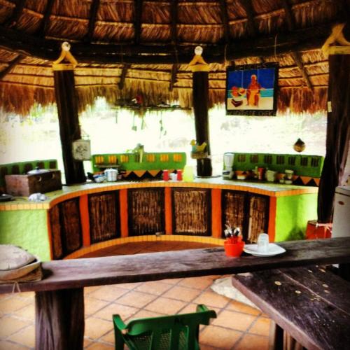 a restaurant with a table and a counter in a room at Acuali EcoHostal in Capurganá