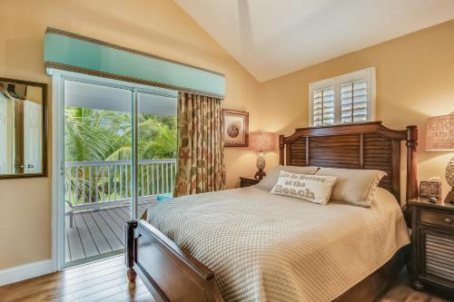 um quarto com uma cama e uma varanda em Harbor Villa em Duck Key