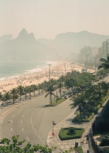 vistas a una playa con palmeras y a una carretera en Hotel Arpoador, en Río de Janeiro