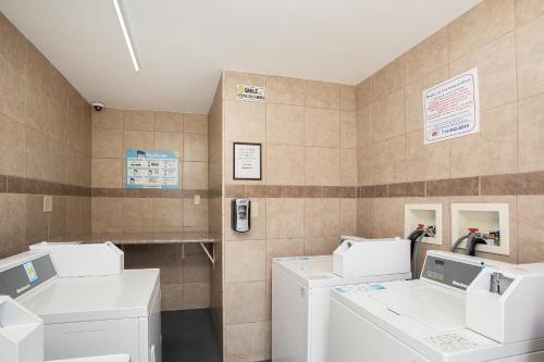 a laundry room with washers and dryers at Stanford Inn & Suites Anaheim in Anaheim