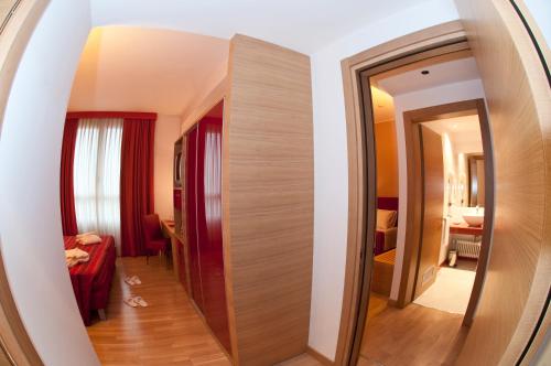 a hallway in a hotel room with a mirror at B&B HOTEL Remilia in Reggio Emilia