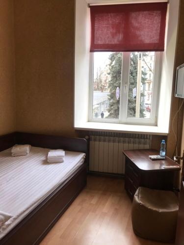 a small bedroom with a bed and a window at Apart-Hotel City Center Contrabas in Lviv