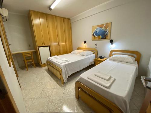 a hotel room with two beds and a table at Missouri Hotel in São Paulo