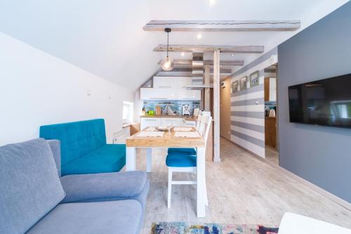 a living room with a table and a couch at Apartament NaFali in Niechorze