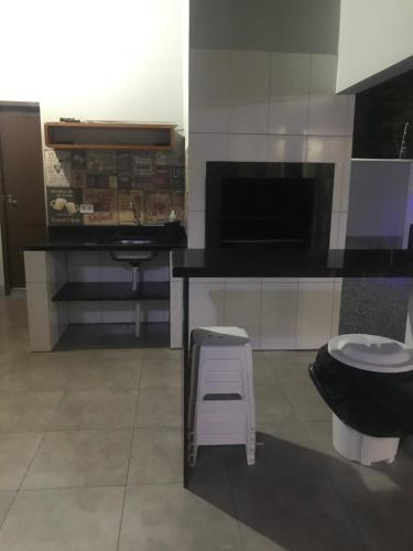 a bathroom with a toilet and a stool and a sink at Residencial Flat Debora in Florianópolis