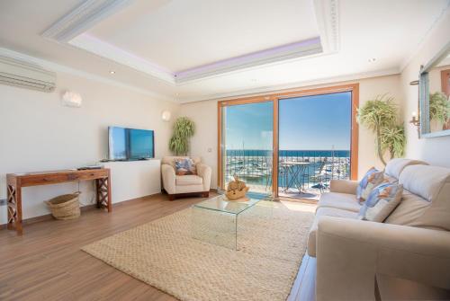 - un salon avec un canapé et une grande fenêtre dans l'établissement Puerto Banus first line with sea and Marina views, à Marbella