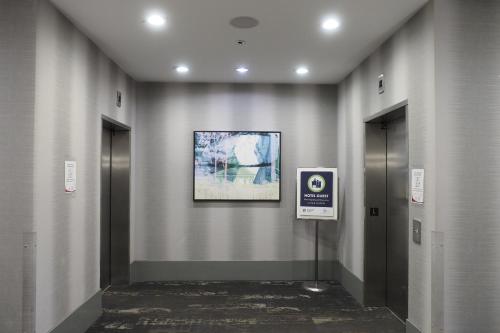 a hallway with two elevators and a picture on the wall at Best Western Plus Vancouver Airport Hotel in Vancouver