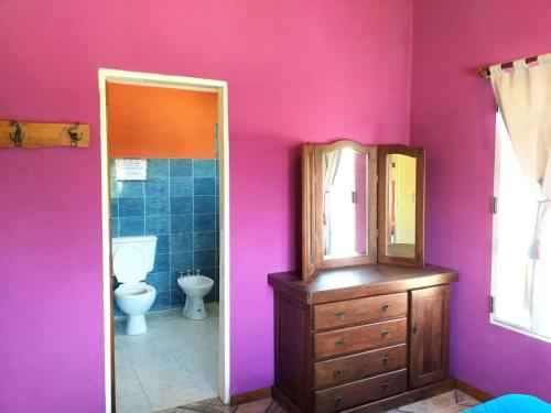 Un baño con inodoro, lavabo y espejo. en Sierra Magenta, en Los Hornillos