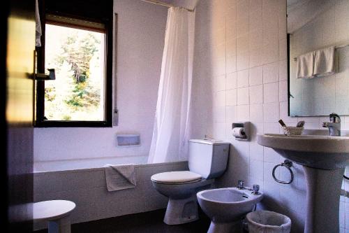 シスポニーにあるホテル ラ ブルナ パノラミクのトイレと洗面台を備えた白いバスルーム