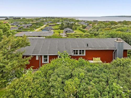 uma casa vermelha com um telhado cinzento e árvores em 6 person holiday home in Lemvig em Lemvig
