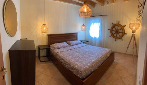 Schlafzimmer mit einem Bett, einem Fenster und Lichtern in der Unterkunft Casa Duse Vista Laguna in Chioggia